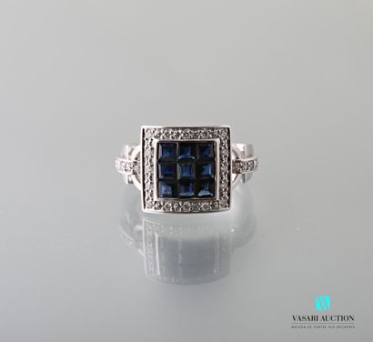 null A 750 thousandths square white gold ring centered on nine princess cut sapphires...