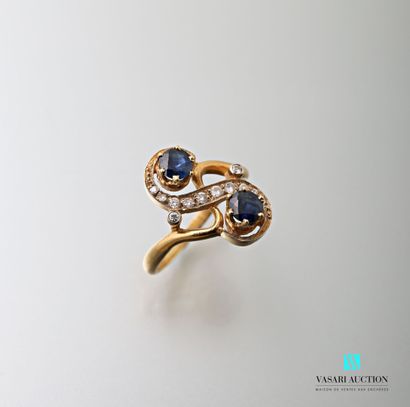 null 750-thousandths yellow gold ring set with two round sapphires and an S-shaped...