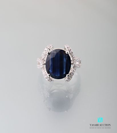null 750 thousandth white gold ring set in its centre with an oval-shaped sapphire...