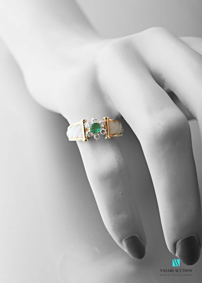 null 750 karat yellow gold ring with a floral motif of a central emerald surrounded...