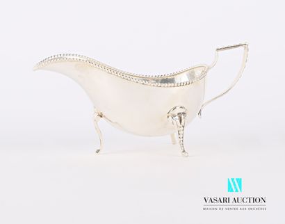 null A silver sauceboat standing on three arched legs, the rim hemmed with a frieze...