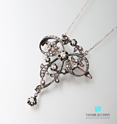 null A platinum chain holding a gold and silver brooch pendant with scrolls and foliage,...
