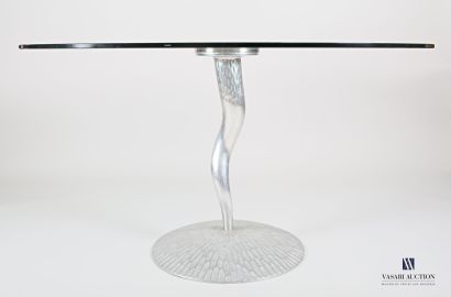 null Round table with a translucent glass top, resting on a sinusoidal base with...