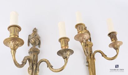 null A pair of ormolu sconces with two arms of light topped by a fire pot, the shaft...