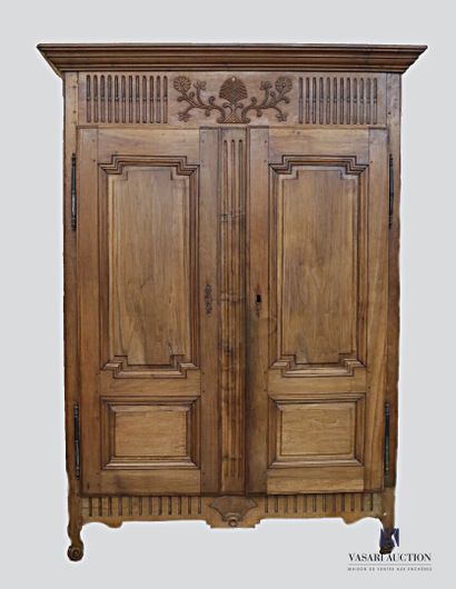 null The cabinet is made of molded and carved natural wood. It opens with two leaves...