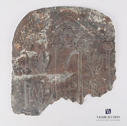 null Cast iron plate showing a stylized temple with a mascaron in its pediment.

Probably...