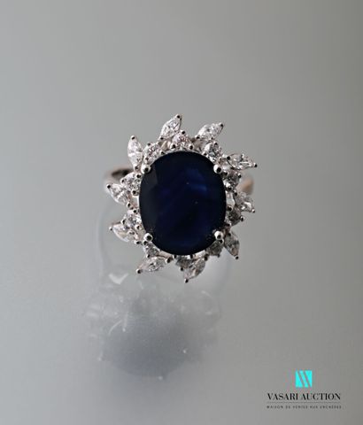 null Flower ring in white gold 750 thousandths decorated in its center with a sapphire...