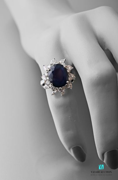 null Flower ring in white gold 750 thousandths decorated in its center with a sapphire...