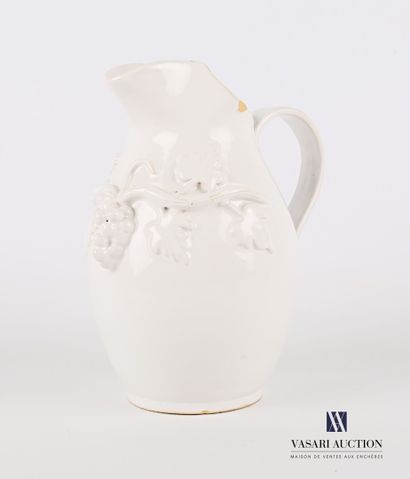 null Earthenware pitcher of ovoid form enamelled white with decoration in relief...