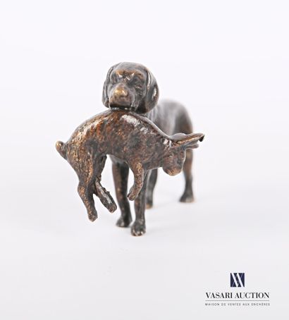 null Bronze subject with brown patina showing a hunting dog holding a hare in its...