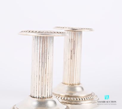 null Pair of silver-plated candlesticks on a round base with a hem of pearls, the...