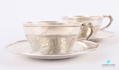 null Two silver cups and their saucers, one decorated with a reserve figure between...