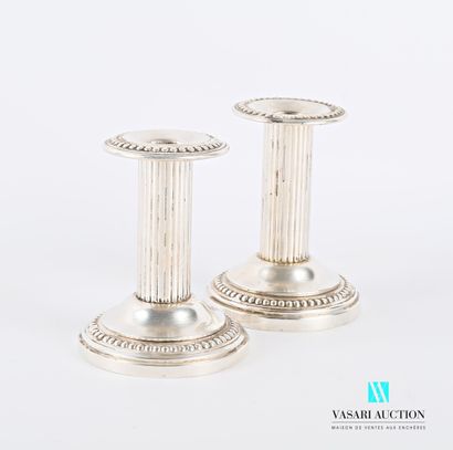 null Pair of silver-plated candlesticks on a round base with a hem of pearls, the...