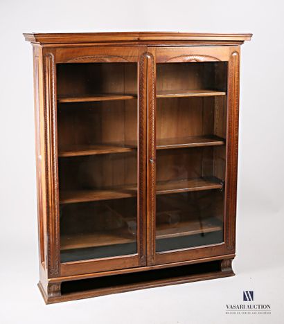 null Natural wood bookcase, molded and carved, it opens on the front with two glass...