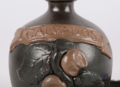 null A stoneware varnished jug decorated with apples and marked "Calvados", the stopper...