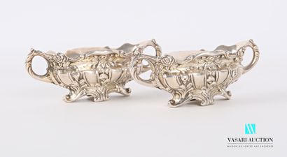 null A pair of silver saltcellars in the form of oblong basins standing on four scrolled...
