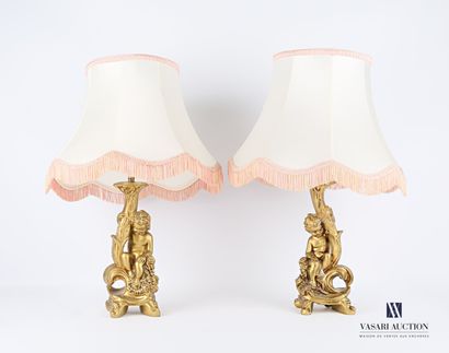 null Pair of lamp bases in carved and gilded resin, the shaft showing young children...