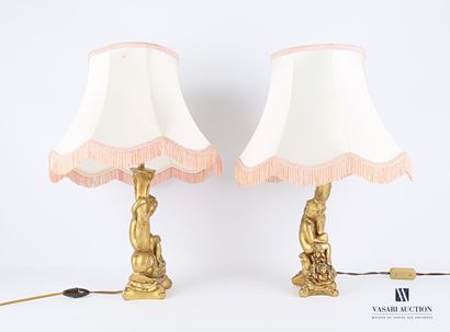 null Pair of lamp bases in carved and gilded resin, the shaft showing young children...