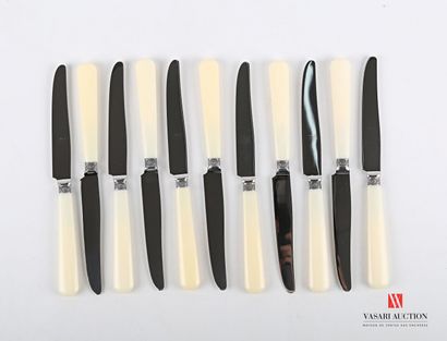 null Suite of twelve dessert knives, the handles in composition are surmounted by...