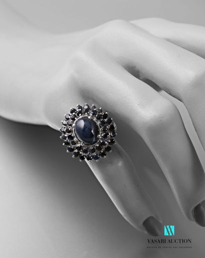 null Silver ring set with a cabochon sapphire hemmed with two lines of treated sapphires

Gross...