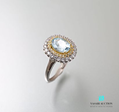 null Silver ring set in its center with an oval blue topaz hemmed with a double row...