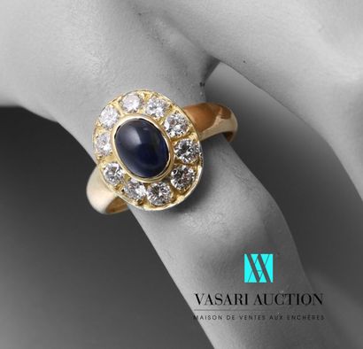 null Ring in yellow gold 750 thousandth set with a central sapphire cabochon surrounded...