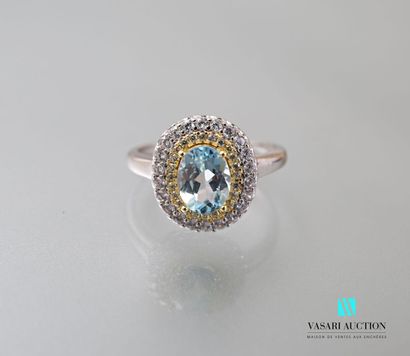 null Silver ring set in its center with an oval blue topaz hemmed with a double row...