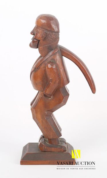 null Carved wooden nutcracker representing a man wearing a vest marked "Wolfach".

Work...