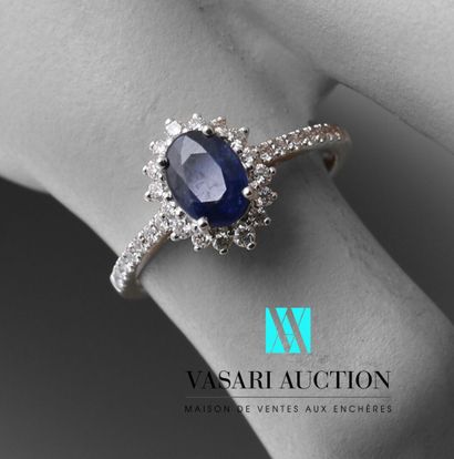 null Daisy ring in white gold 750 thousandth set in its center of a sapphire of oval...