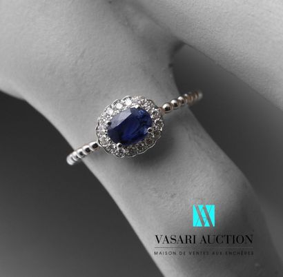 null Ring in white gold 750 thousandth set in its center with an oval sapphire calibrating...
