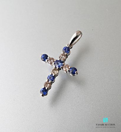 null Cross in white gold 750 thousandth, the arms decorated with six round sapphires...