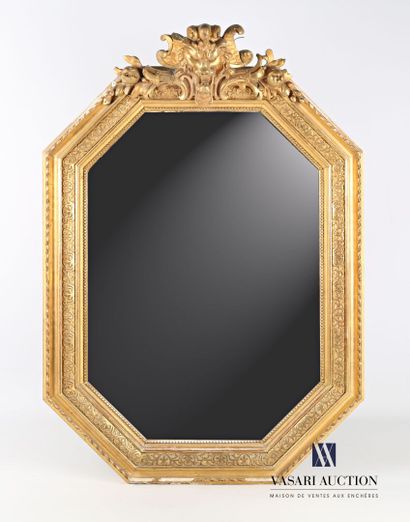 null Wooden mirror and stucco molded, carved and gilded, the beveled mirror of octagonal...