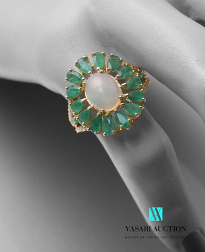 null A vermeil ring set with a cabochon opal in an openwork setting of pear-cut emeralds,...