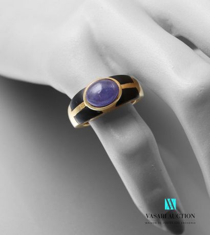 null A vermeil ring set with a cabochon tanzanite and two onyx motifs.

Gross weight:...