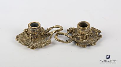 null Pair of bronze hand candlesticks, the binet rests on a bobèche figuring vine...
