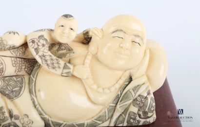 null Sculpture en ivoire représentant un boudha allongé surmonté d'un enfant sur...