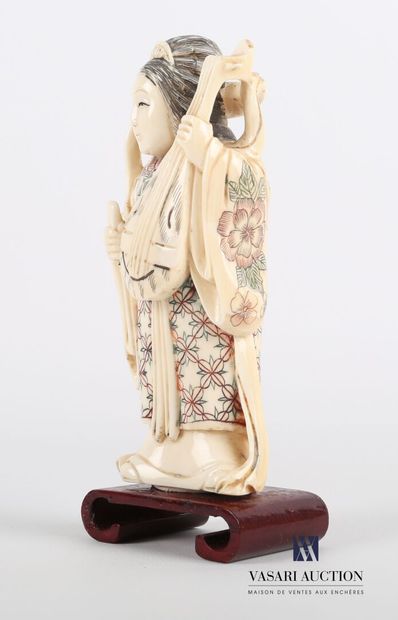 null Okimono en ivoire à décor polychrome représentant une femme debout tenant dans...