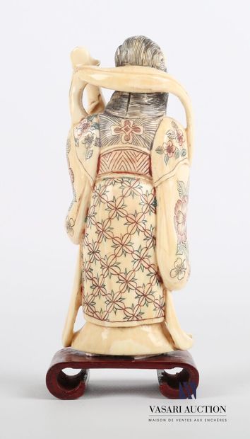 null Okimono en ivoire à décor polychrome représentant une femme debout tenant dans...