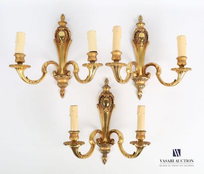 null Suite of three sconces in bronze, the tapered shaft has a blind cartouche supporting...