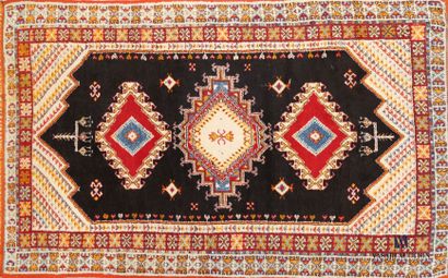 null NORTH AFRICA

Wool carpet decorated with three rhombus medallions on black background,...