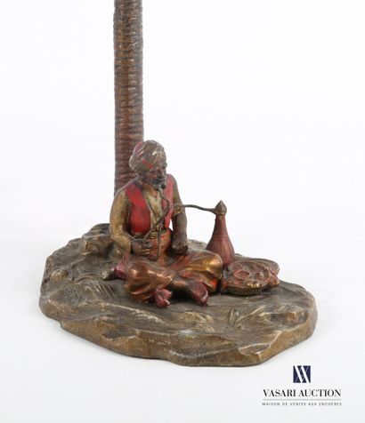 null Metal lamp with polychrome patina representing a seated Bedouin smoking hookah...