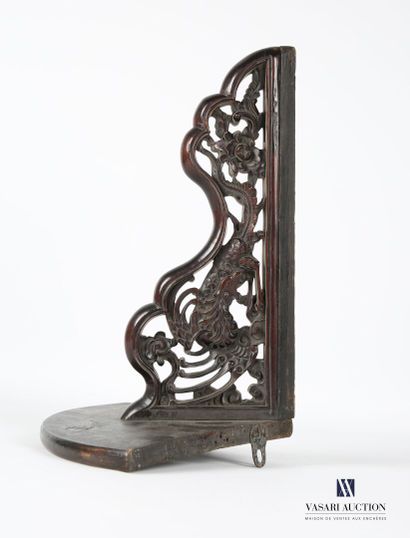 null Wall bracket in natural tinted wood, standing on an openwork console decorated...