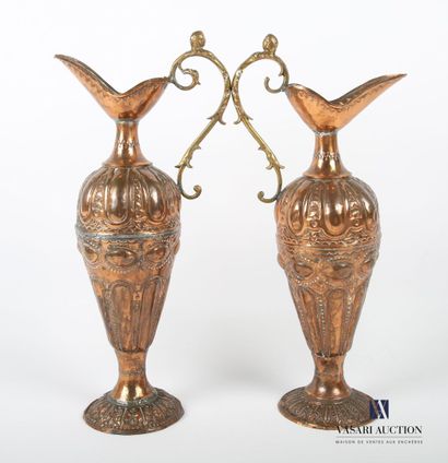 null Two ewers in embossed copper, the body decorated with friezes of gadroons and...