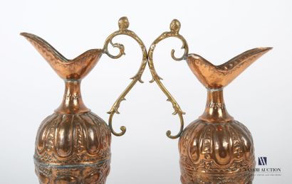 null Two ewers in embossed copper, the body decorated with friezes of gadroons and...