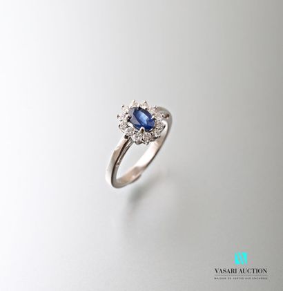 null Daisy ring in white gold 750 thousandth set in its center with an oval sapphire...