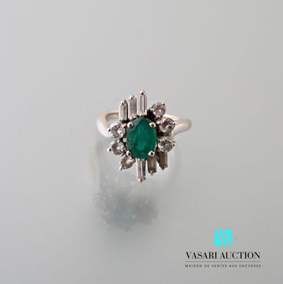 null Ring in white gold 750 thousandth set with a central oval emerald surrounded...