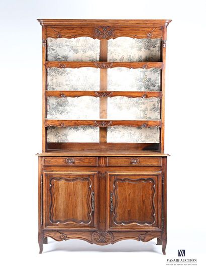 null Vaisselier in molded and carved oak, the upper part has three shelves decorated...