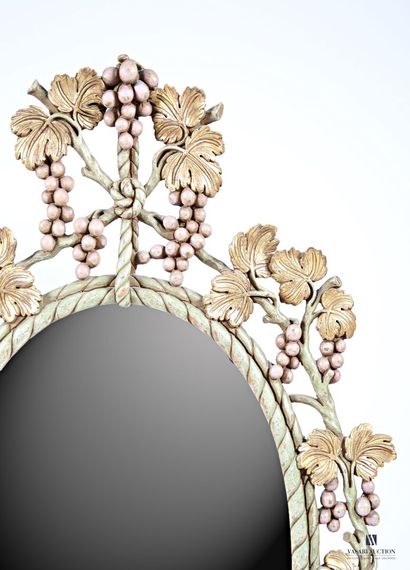null Mirror of oval form out of painted and carved wood, the edge openwork of vine...