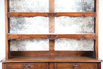 null Vaisselier in molded and carved oak, the upper part has three shelves decorated...
