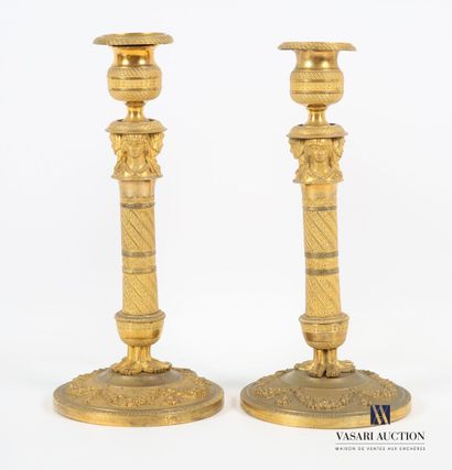 null Pair of gilt bronze candlesticks standing on a round base hemmed with garlands...